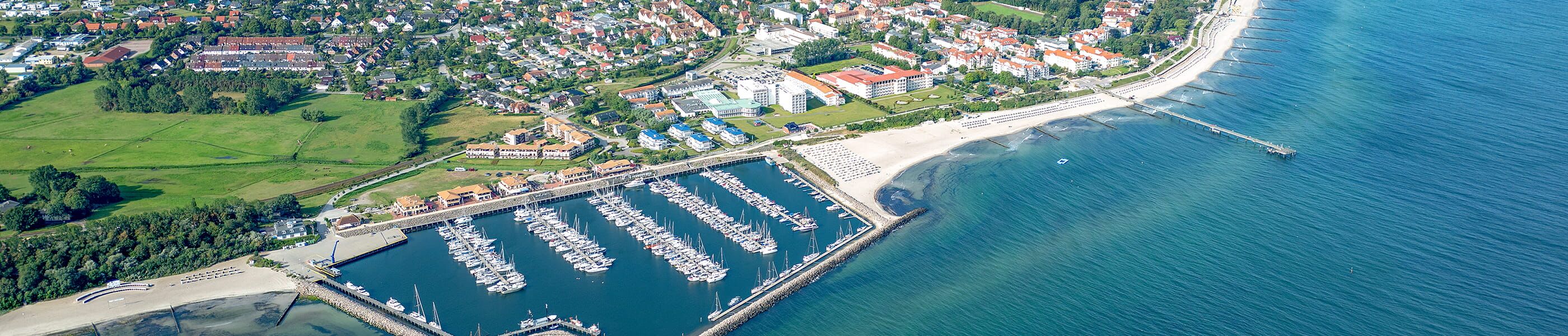 Luftaufnahme von Kühlungsborn mit Yachthafen, Strand und Ferienwohnungen entlang der Ostseeküste